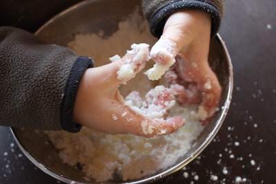 A boy's hands mixing play snow