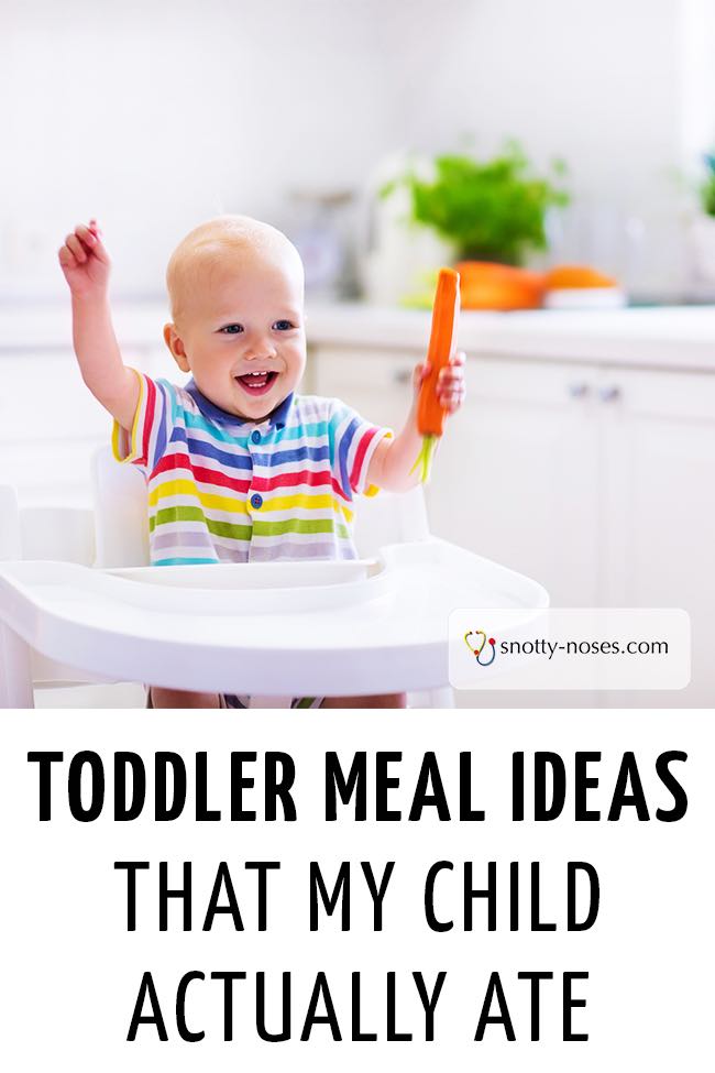 A toddler boy sitting at a high chair and holding a carrot. #fussyeater #pickyeater #fussytoddler 